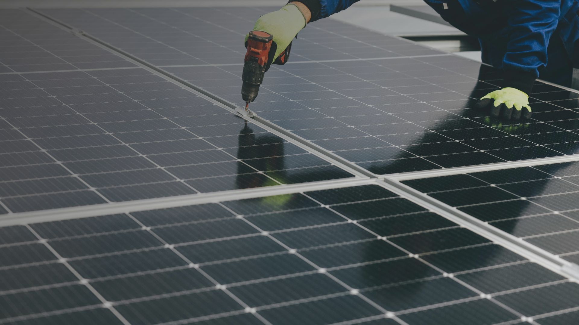 Engineer installing solar PV panels on the slate roof of a UK home